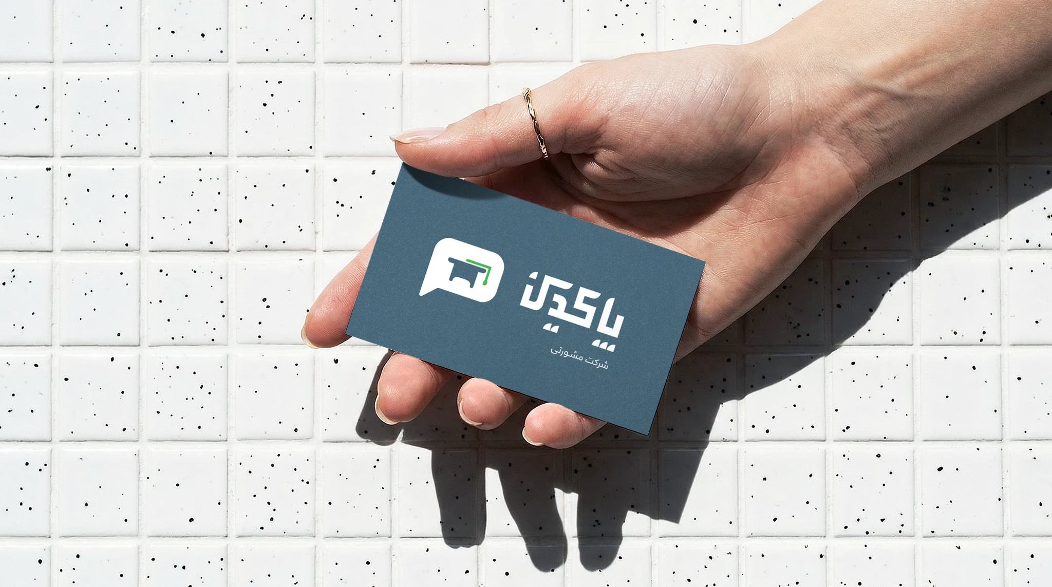 Pakdin business card held in hand